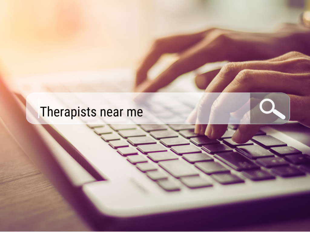 Fingers search for 'therapists near me' as a person figures out how to find a therapist