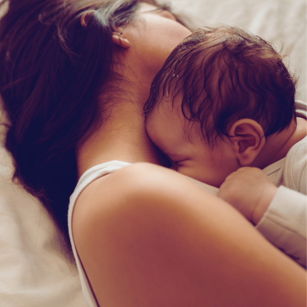 A new moms snuggles her baby after experiencing birth trauma.
